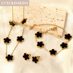 Gold-tone clover jewelry set with black enamel necklace, bracelet, and stud earrings