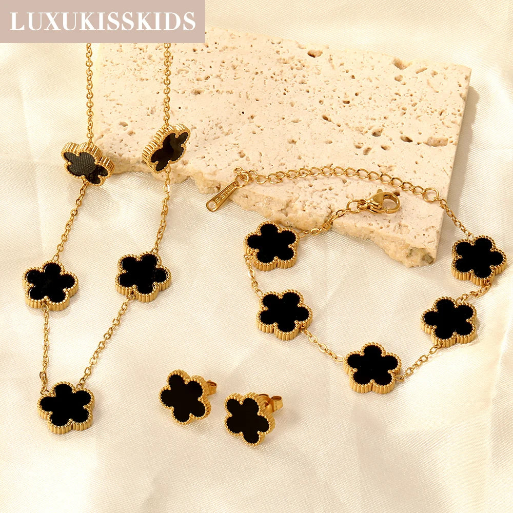 Gold-tone clover jewelry set with black enamel necklace, bracelet, and stud earrings
