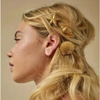 Gold starfish hair clip with scallop-shell accents on long blonde hair