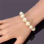Pearl bracelet with large pearls and gold-tone crystal rings, worn on wrist