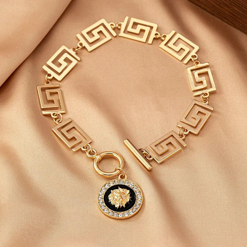 Gold embossed chain anklet with Greek-key links and round lion medallion charm