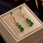 Gold hoop earrings with green gemstone bar dangle and textured chain