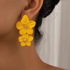 Yellow double-layer flower dangle earrings on ear with gold-tone star centers