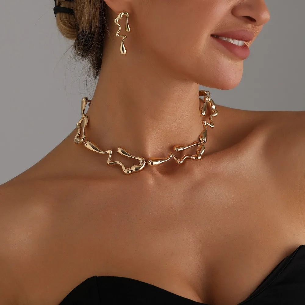 Gold-tone choker necklace with abstract lava-drop links and matching drop earrings