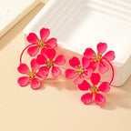 Red camellia-style flower dangle earrings with gold-tone star centers and hoop links