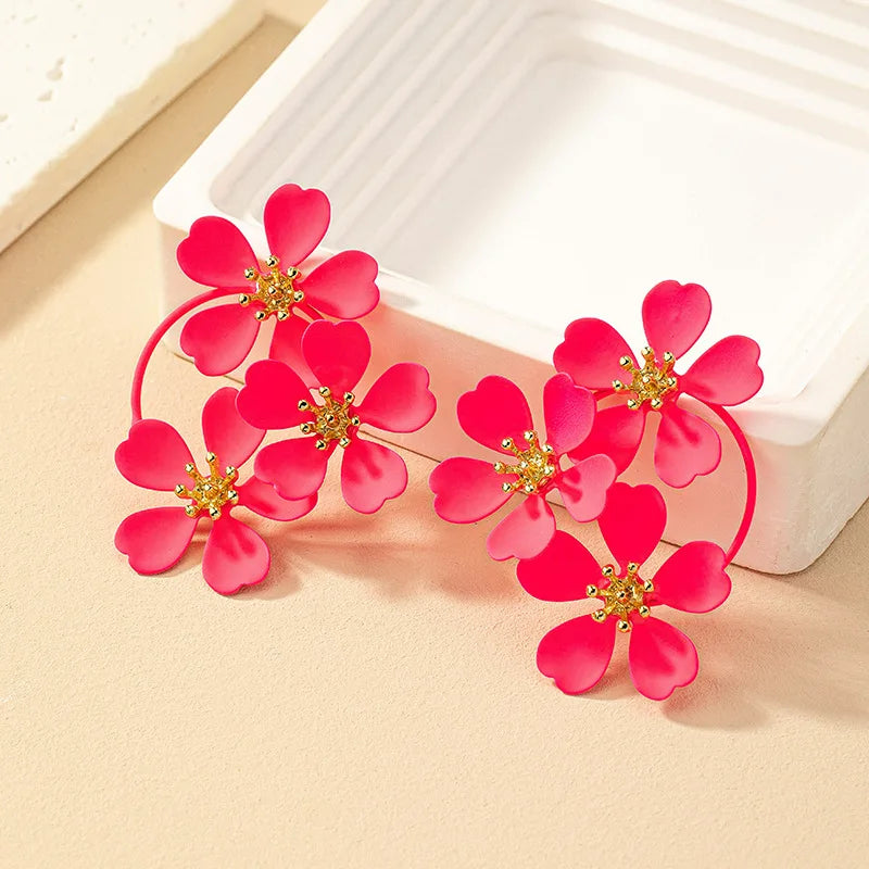 Red camellia-style flower dangle earrings with gold-tone star centers and hoop links