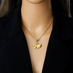 Gold-tone ginkgo leaf pendant necklace with turquoise round stone, worn on neck