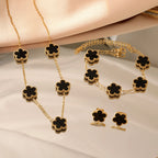 Gold-tone clover jewelry set with black enamel necklace, bracelet, and stud earrings