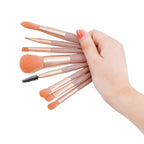 Makeup brush set with rose-gold handles and orange bristles; includes black spoolie