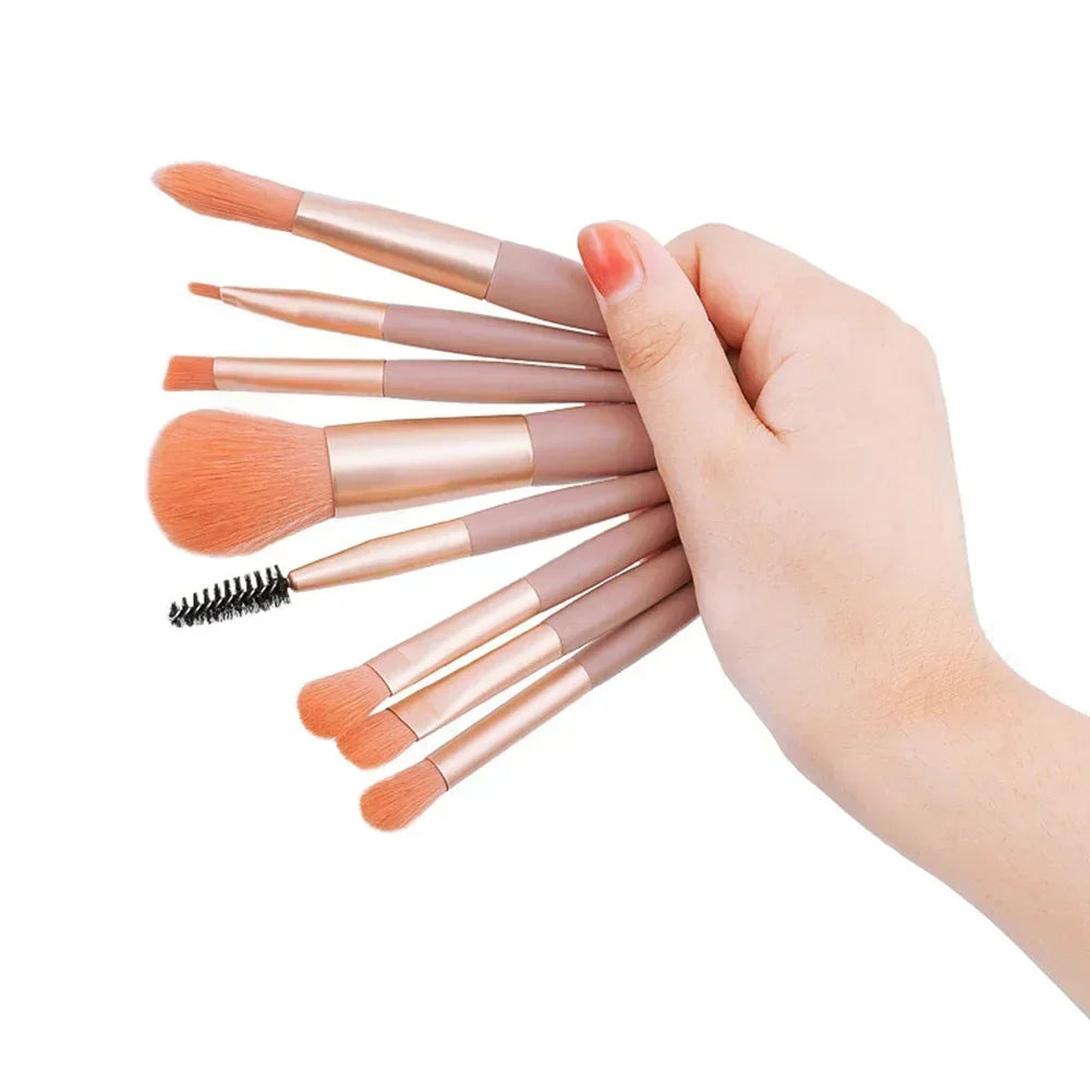 Makeup brush set with rose-gold handles and orange bristles; includes black spoolie