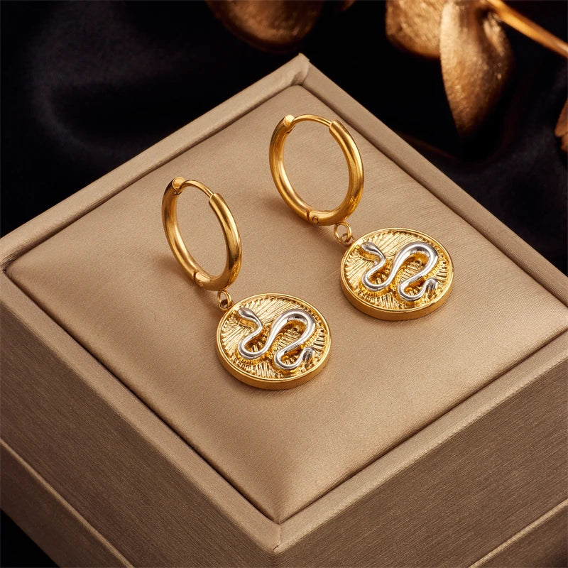 Gold hoop earrings with round embossed heart pendant, no visible stones