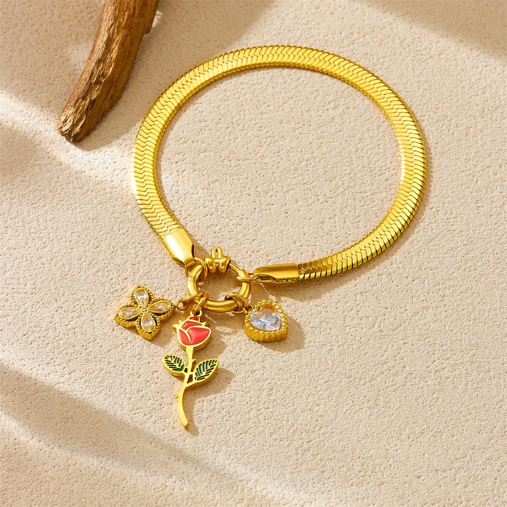 Gold-tone snake bracelet with rose, heart, and red flower charms