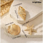 Gold starfish, scallop shell, and clam shell hair clips arranged on white background