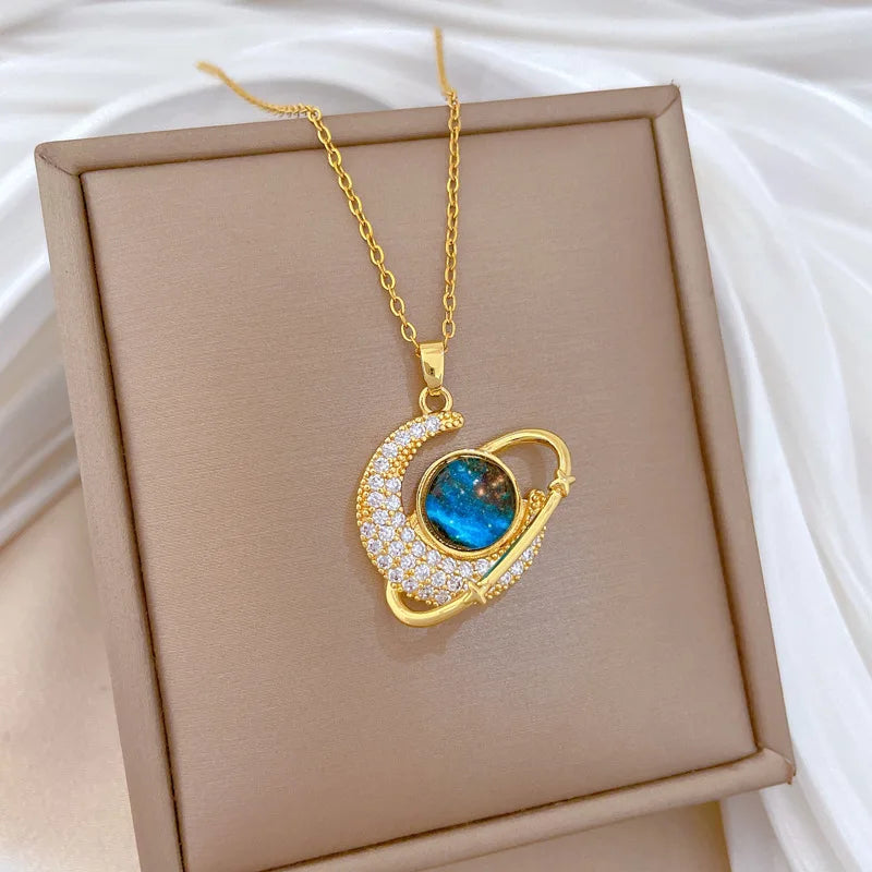 Gold-tone heartlike pendant necklace with blue oval gemstone and rhinestone border