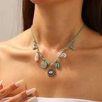 Turquoise beaded pendant necklace with moon, eye, pearl drops and heart charms
