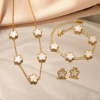 Gold-tone clover jewelry set with white enamel necklace and bracelet, plus stud earrings