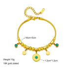 Gold-tone charm bracelet with green stone beads, sunburst pendant, and round coin charms