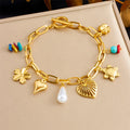 Gold-tone charm bracelet with flower, heart, shell, pearl and turquoise bead charms