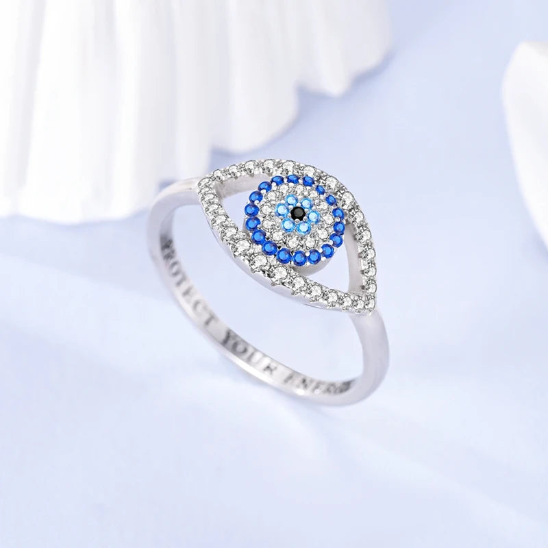 Sterling silver evil eye ring with blue eye centerpiece and crystal-detailed band