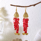 Gold-tone koi charm drop earrings with red bead clusters and fish-tail charms.