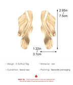 Gold-tone textured curved oval stud earrings with a wavy surface