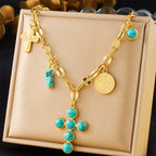 Gold-tone cross pendant necklace with turquoise stone-bead and coin charms