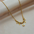 Gold-tone charm necklace with small hoop accents and blue zircon center