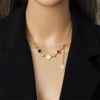 Gold-tone five-petal flower pearl necklace worn at the collar with charm and pearl beads