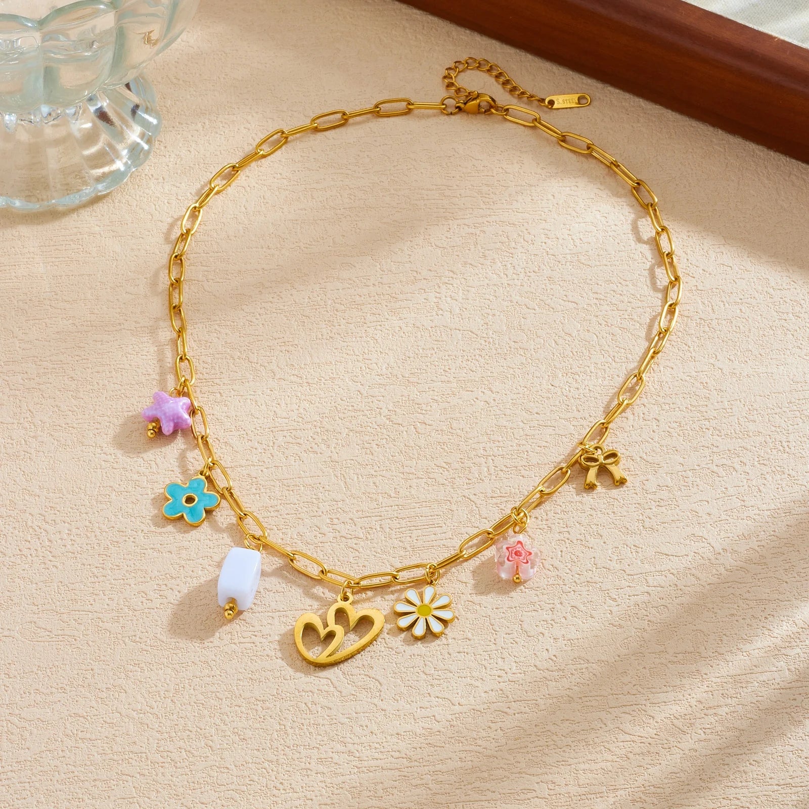 Gold enamel pendant necklace with heart center charm and colorful flower and bow pendants