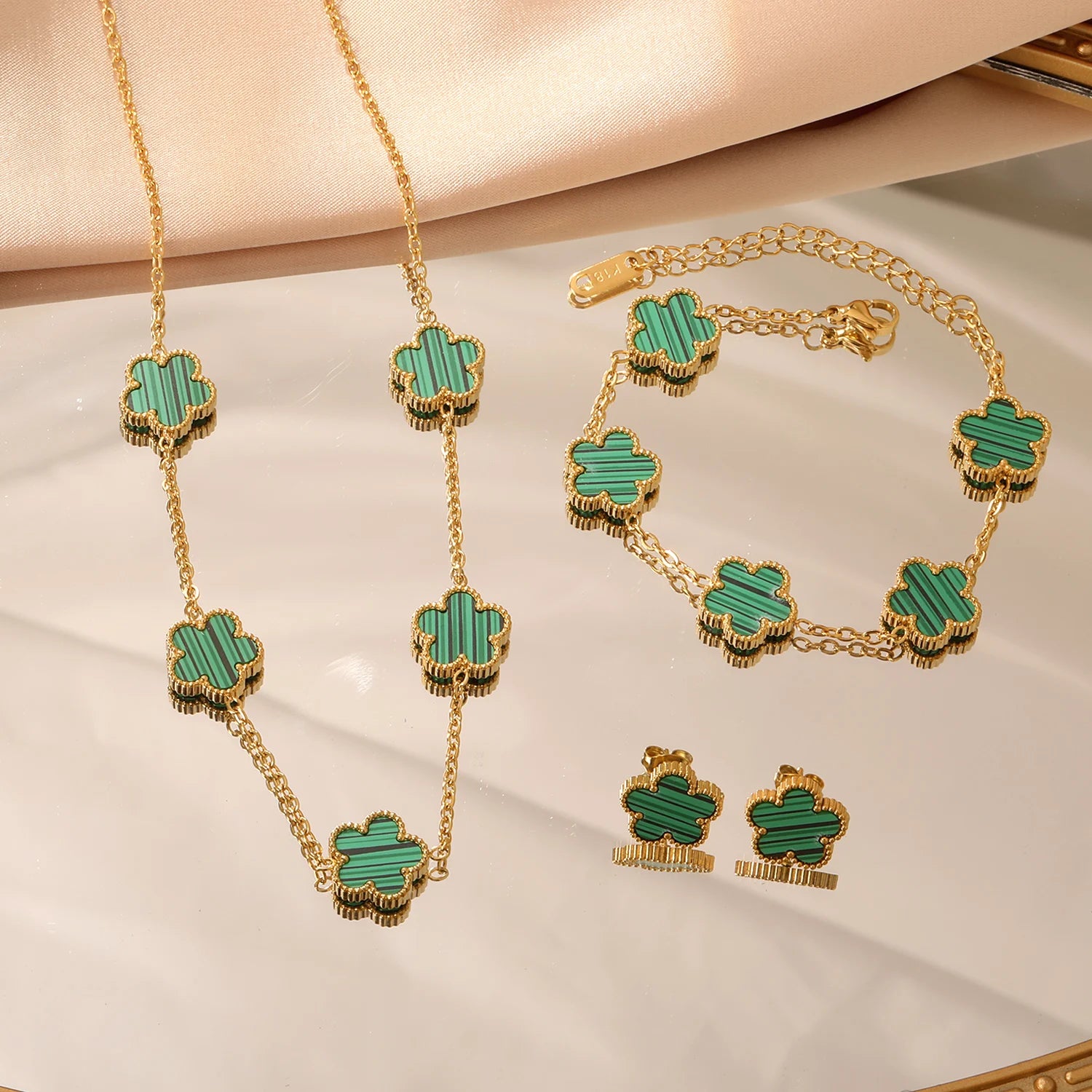 Gold-tone clover jewelry set with green enamel necklace, bracelet, and stud earrings