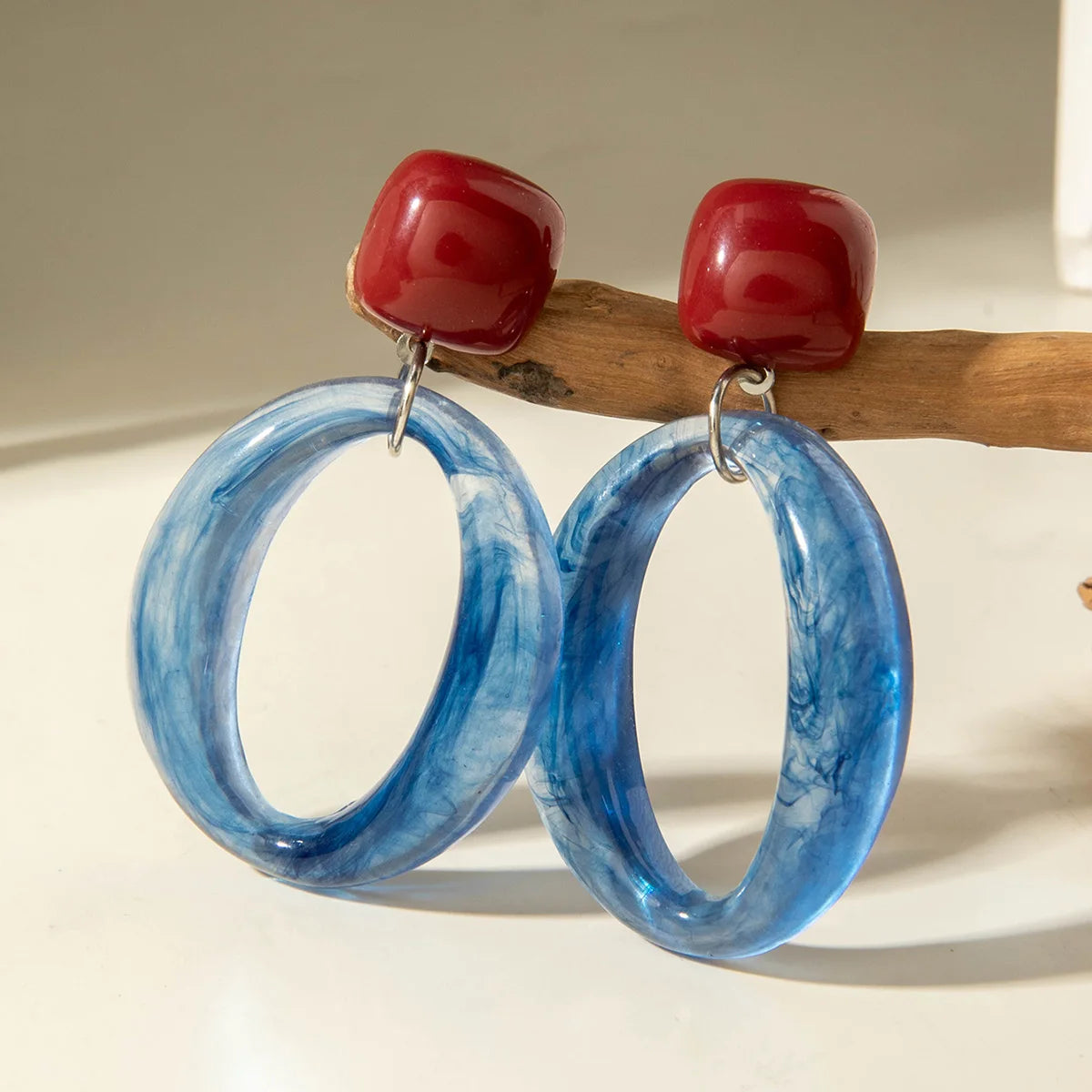 Blue marbled oval hoop drop earrings with red square caps and metal-tone hook backs