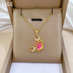 Gold-tone crab pendant necklace with pink center gemstone and bright red rhinestone accents.