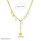 Gold-tone charm necklace with cross pendant, star charms, and pearl bead drops