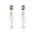 Silver-tone fishbone dangle earrings with black-and-white striped ovals and fish charms