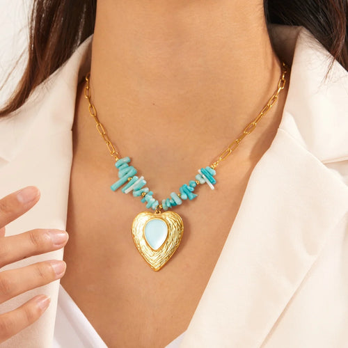 Gold-tone heart pendant necklace with turquoise bead accents and blue heart center.