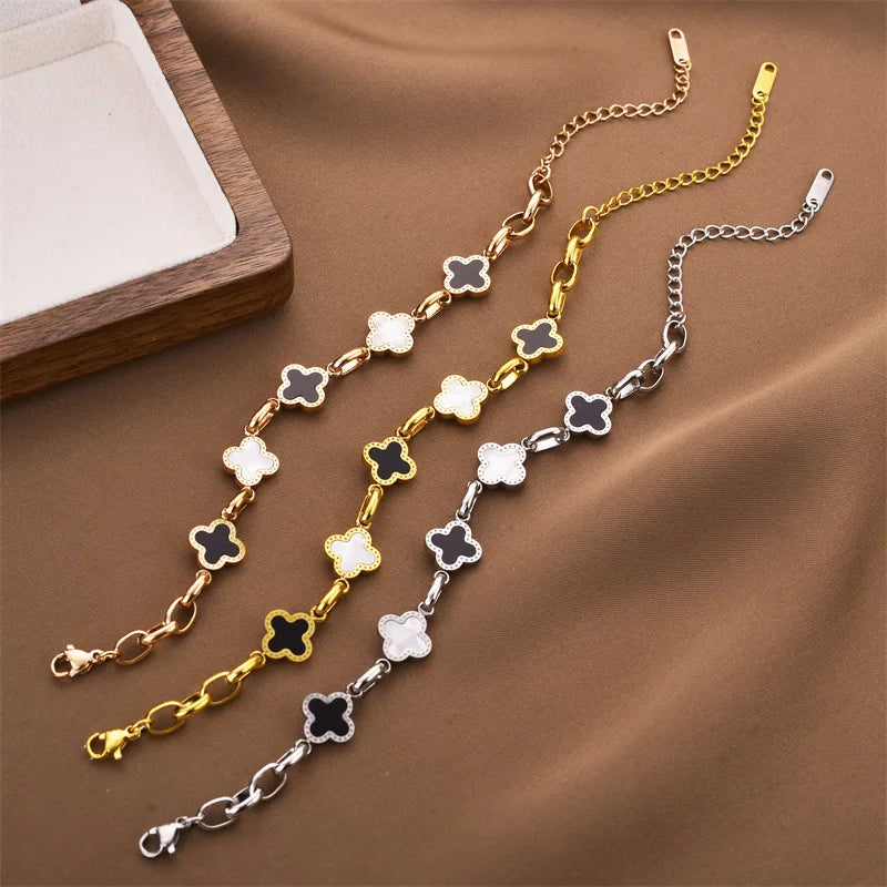 Four-leaf clover charm bracelet with gold-tone chain and white enamel clover charms