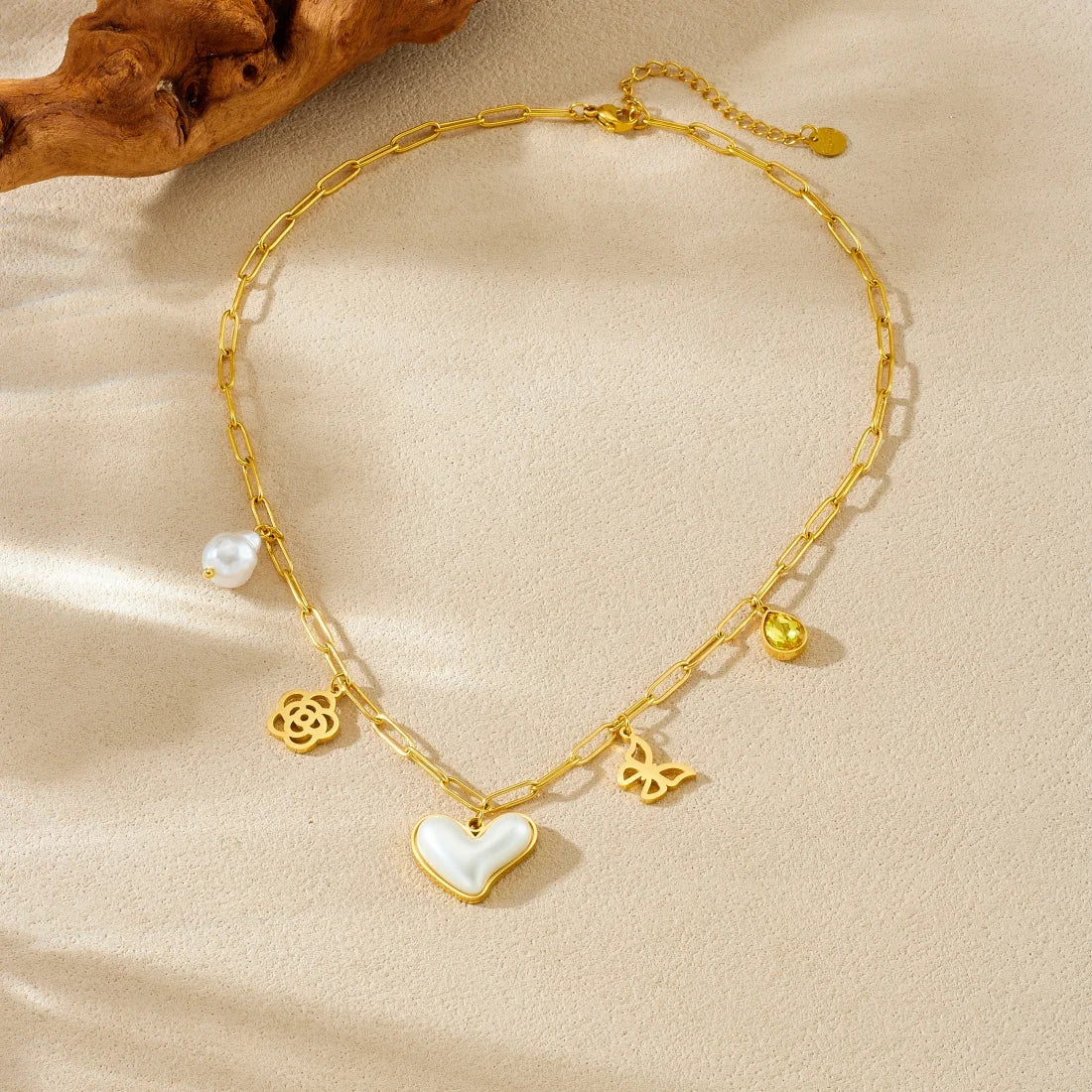 Gold-tone heart pendant necklace with pearl drop and butterfly and flower charms