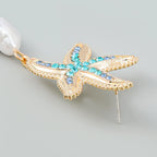 Gold-tone starfish earring with blue and turquoise crystals and a white pearl drop pendant