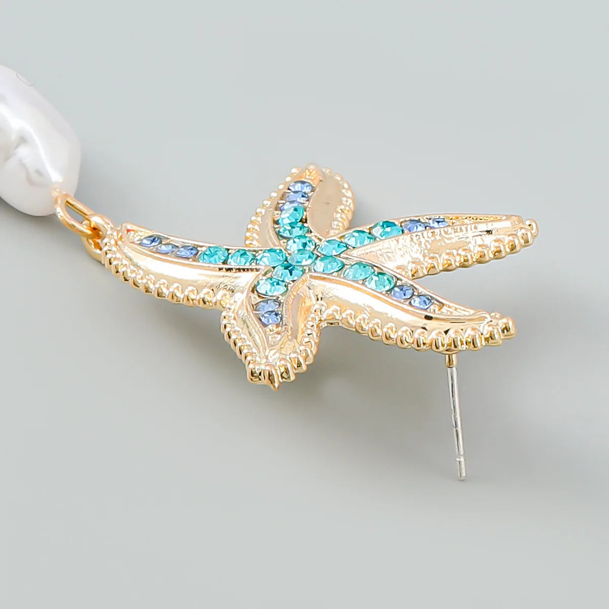 Gold-tone starfish earring with blue and turquoise crystals and a white pearl drop pendant