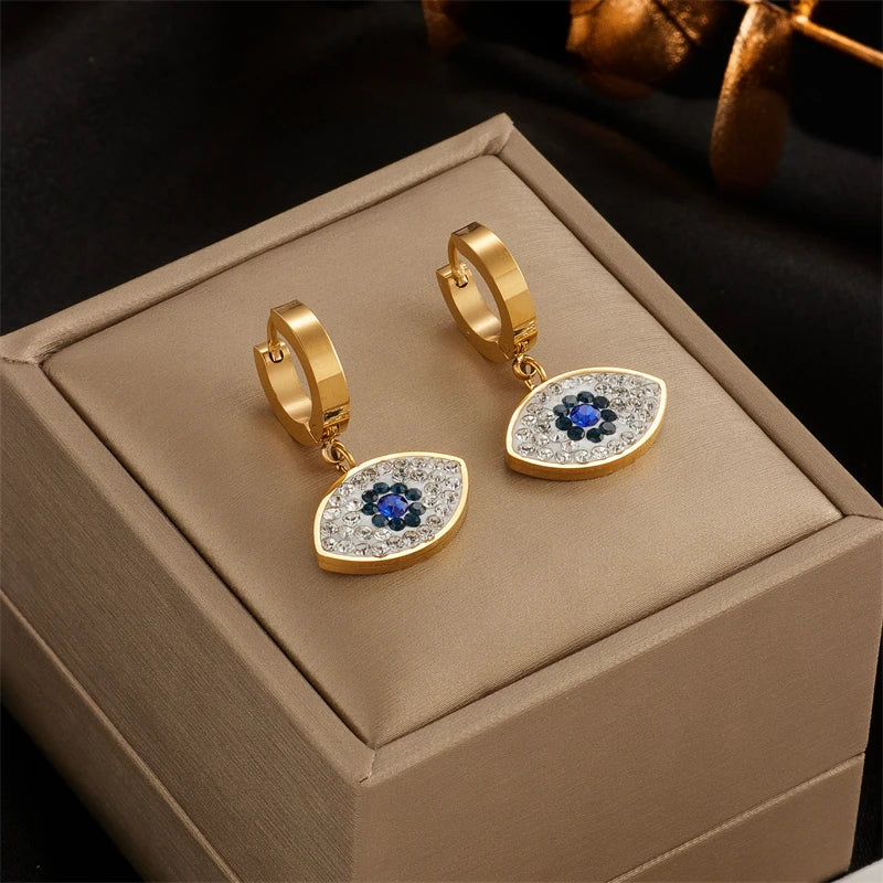 Gold hoop earrings with heart-shaped charm featuring blue center stone and clear accents