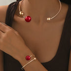 Gold-tone pearl collar necklace with red bead drop; matching red pearl bracelet