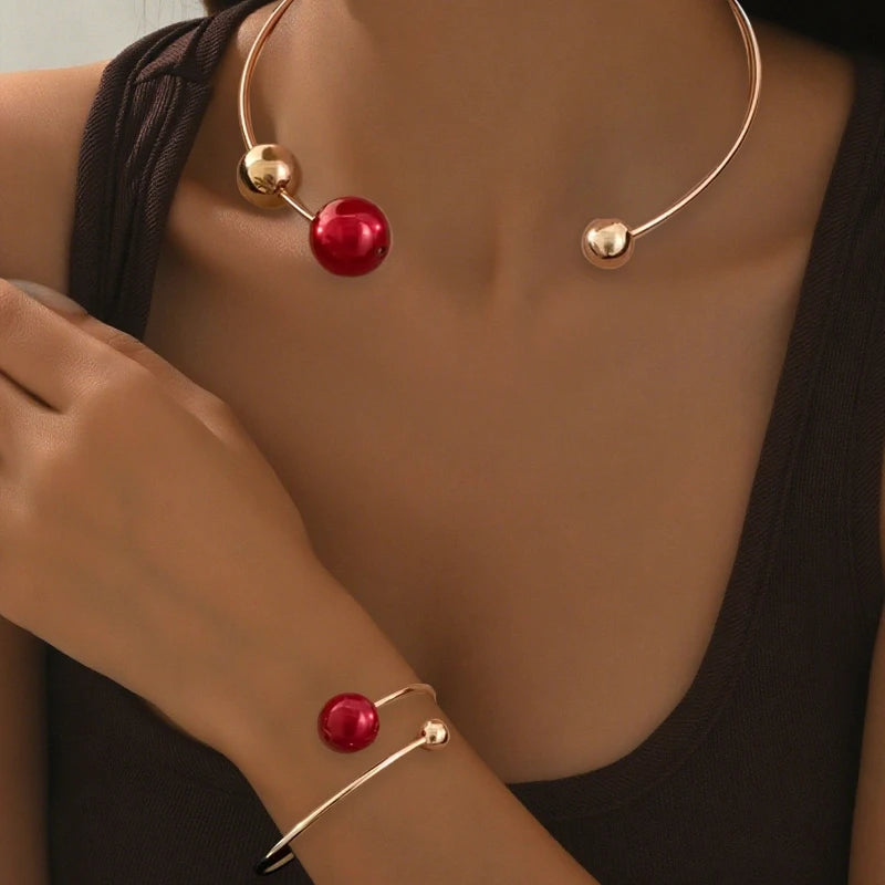 Gold-tone pearl collar necklace with red bead drop; matching red pearl bracelet