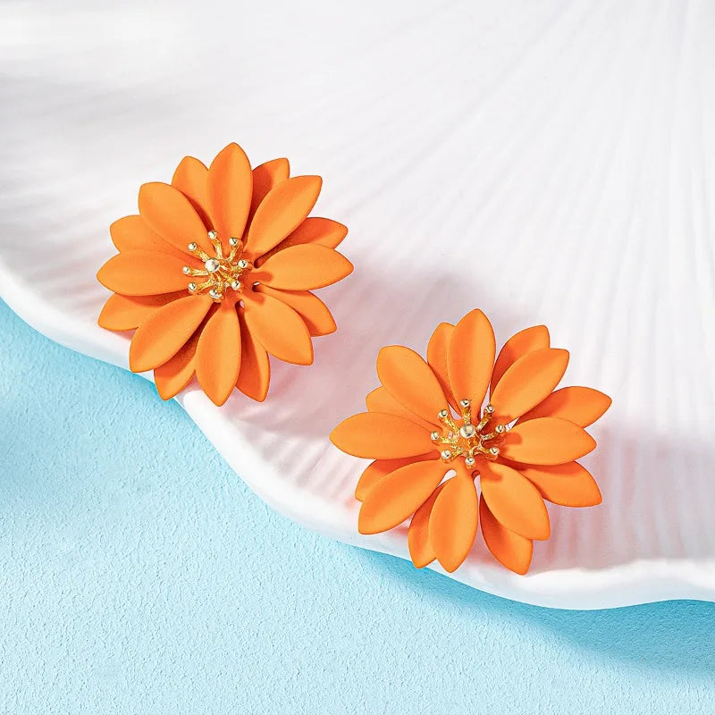 Orange enamel flower stud earrings with gold-tone starburst centers