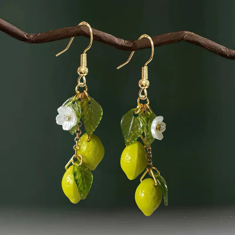 Lemon tassel drop earrings with yellow acrylic lemons, green leaves, and white flower details