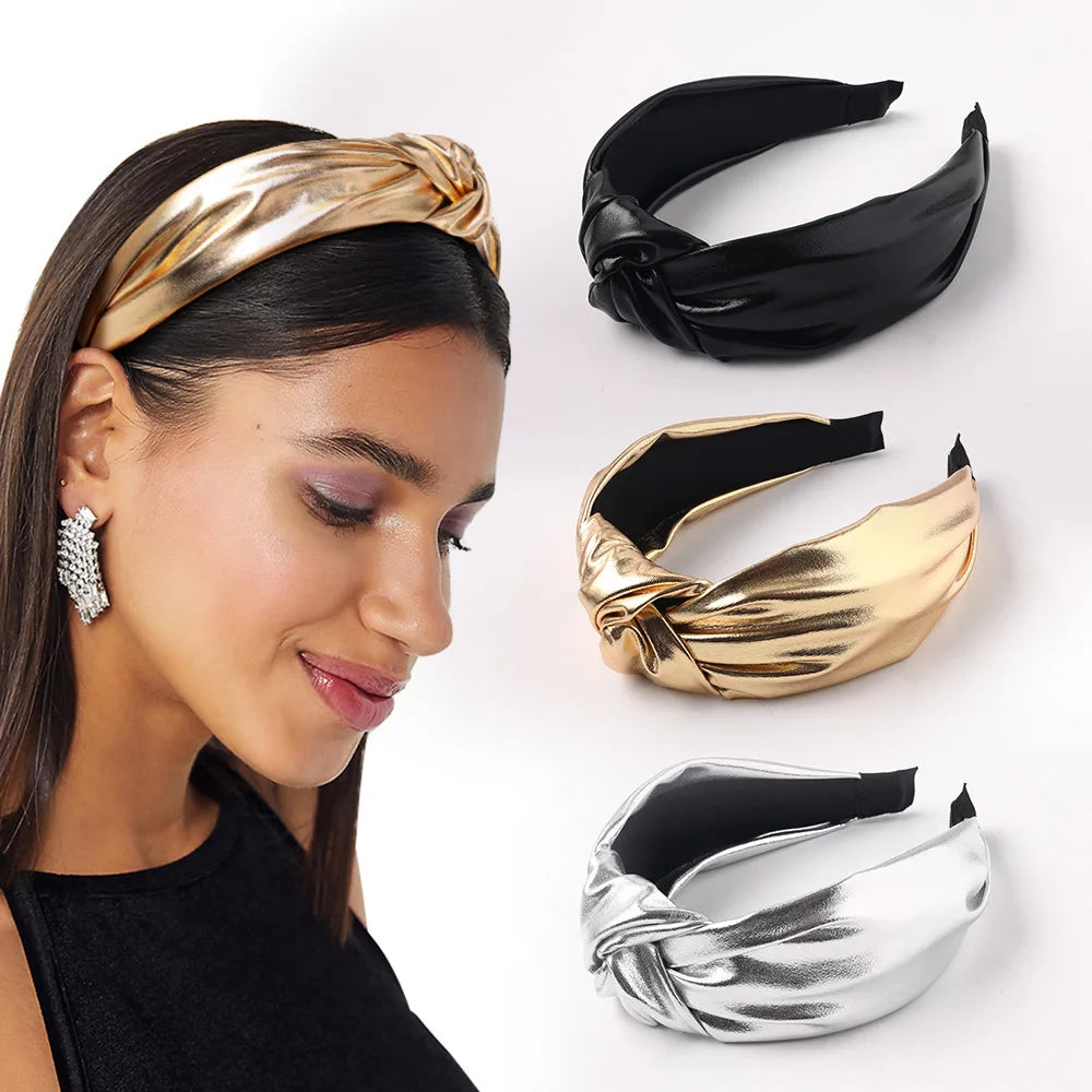 Gold PU leather wide headband with twisted bow on model; black and silver shown