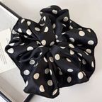 Polka dot black scrunchie with a rounded bow and elastic gathered center