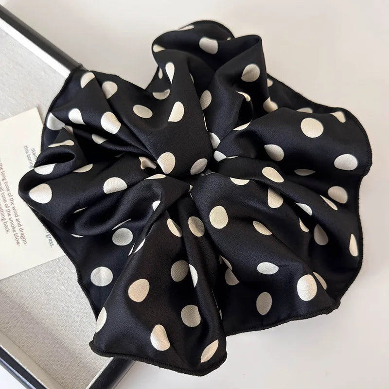 Polka dot black scrunchie with a rounded bow and elastic gathered center