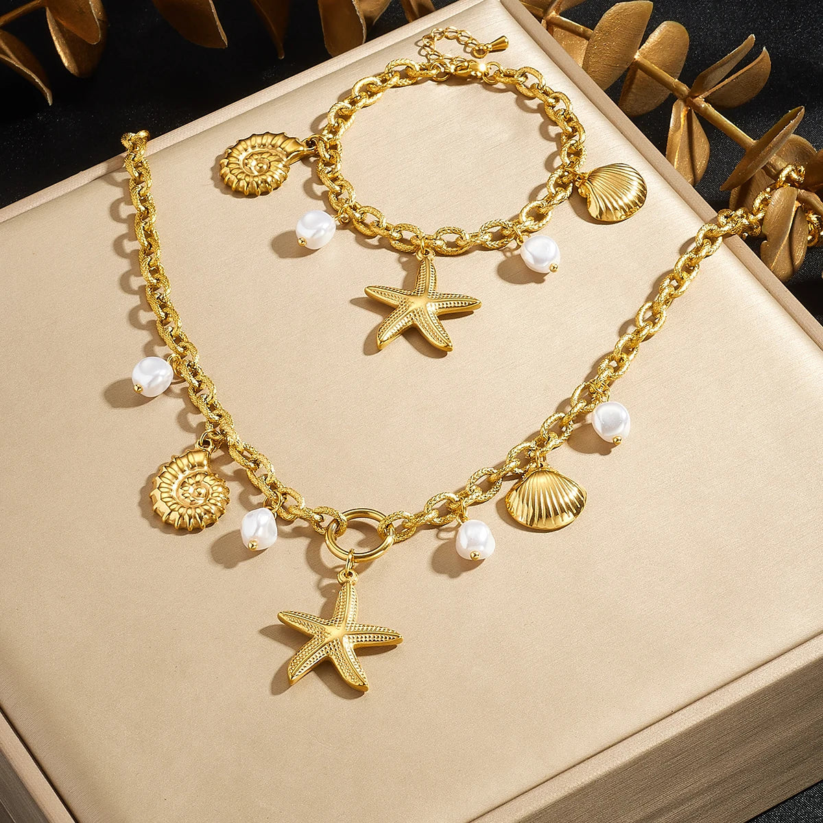 Gold-tone charm necklace set with starfish and seashell charms plus white pearl beads