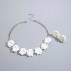 White flower necklace with silver-tone chain and matching stud earrings, flat lay