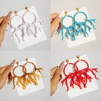 Acrylic drop earrings in white, turquoise, brown, and red with bead hoops and fringe